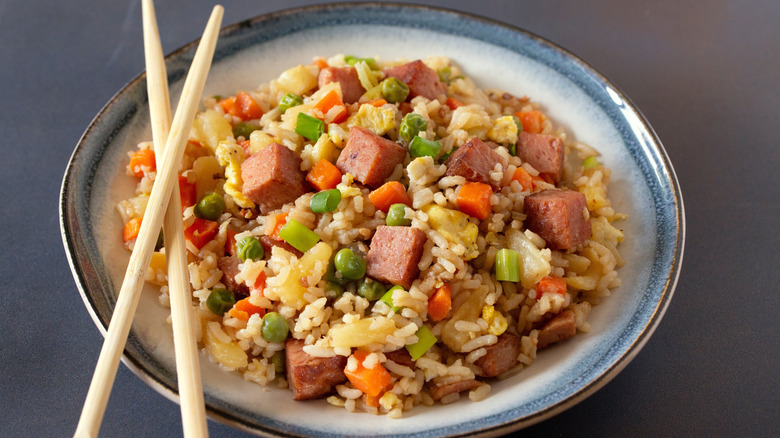 Spam fried rice in a bowl with carrots, eggs, and peas