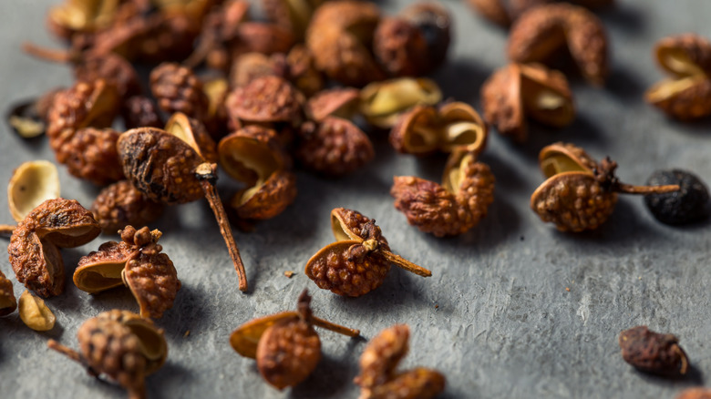 Cracked Szechuan peppercorns on a dark background