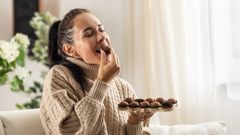 A woman eating chocolate candies.