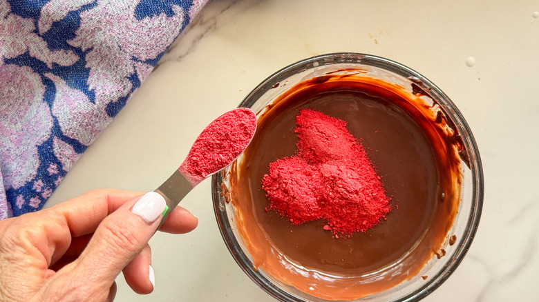 hand adding powder to chocolate