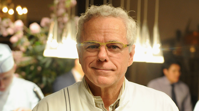A smirking David Bouley in a restaurant dining room. 
