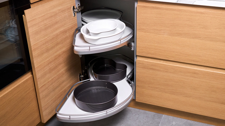 a pull-out kitchen cabinet with kitchen items on the shelves