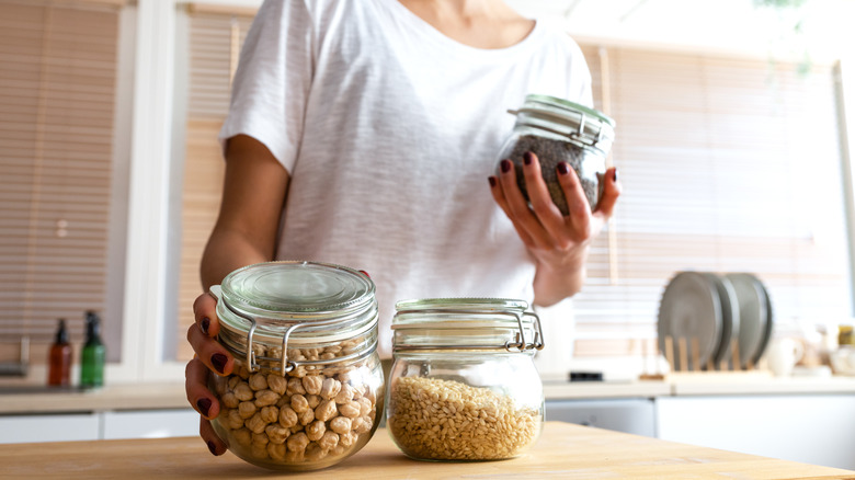woman assessing glass containers of food