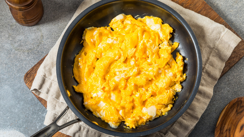 A large pan of scrambled eggs is photographed from overhead.