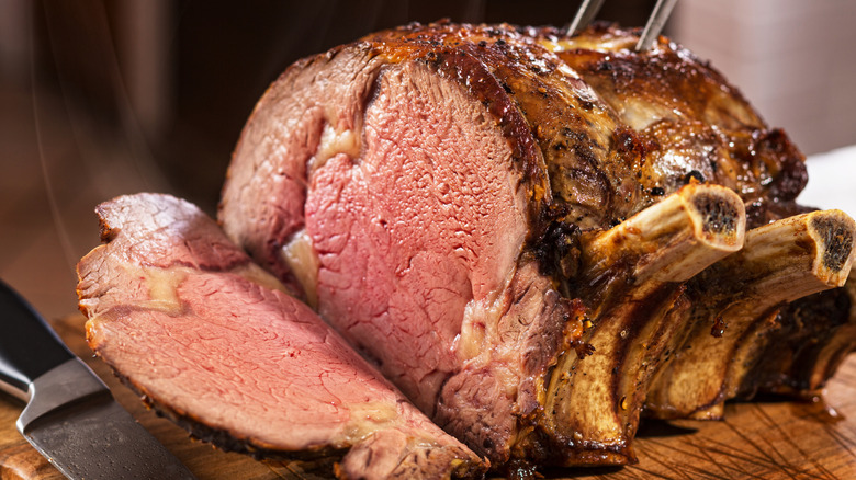 A prime rib roast with a piece partly sliced off