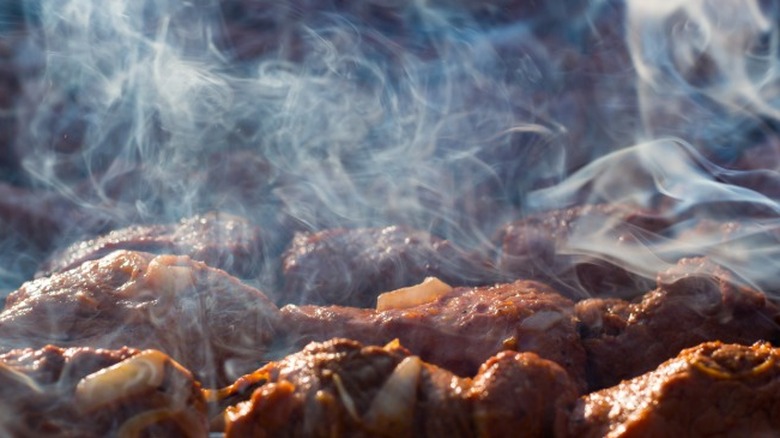 Meat being smoked on a grill.