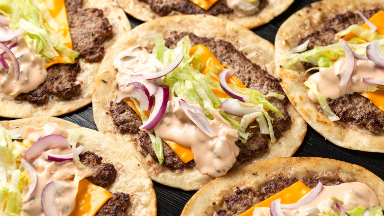 Platter of hamburgers on tortillas.