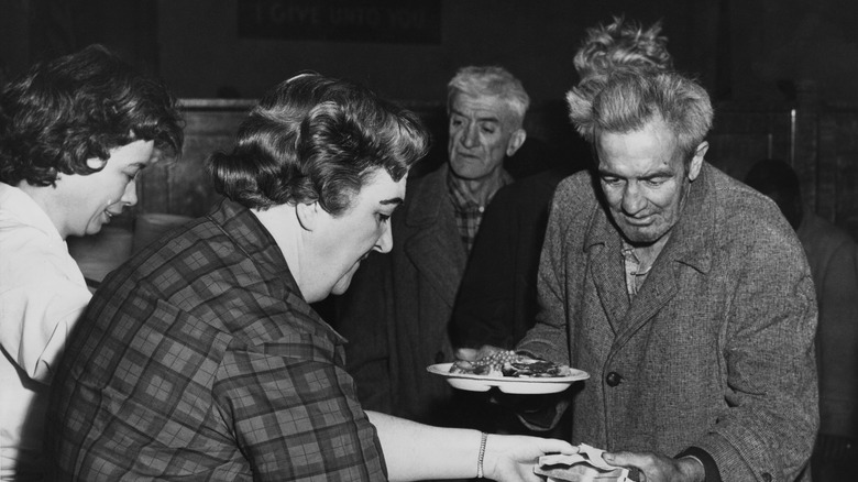 Women serving hungry people a hot meal