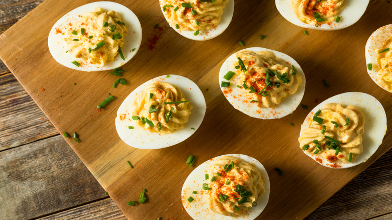 Deviled eggs on a cutting board.