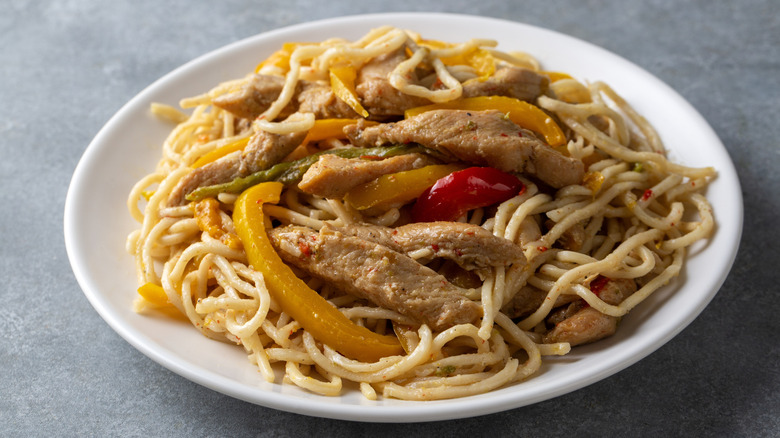 Chicken stir fry with noodles and peppers.
