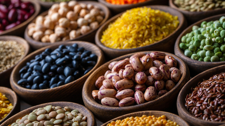 wooden bowls filled with variety of beans and lentils