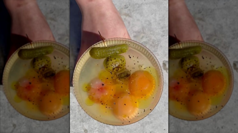 Egg yolks sitting in a salt cure in a baking dish.
