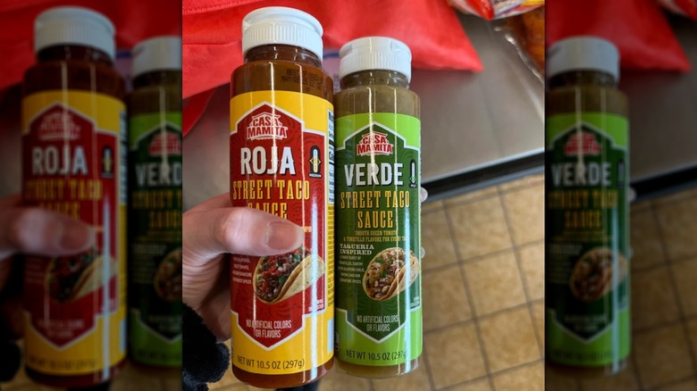 person holding bottles of Casa Mamita Taco Sauces