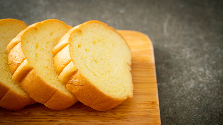 Three slices of potato bread sitting on a cutting board
