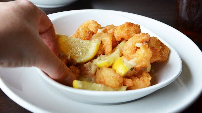 A person taking a piece of shrimp out of a bowl of Spicy Shrimp Scampi Fritta at Olive Garden