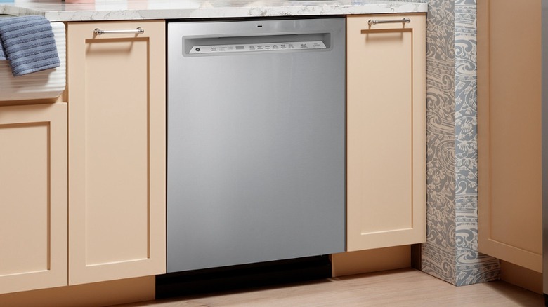 GE dishwasher installed in a kitchen with tan cabinets