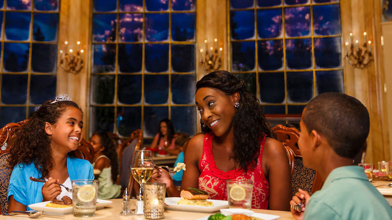 A mom and her two kids eating at the Be Our Guest restaurant
