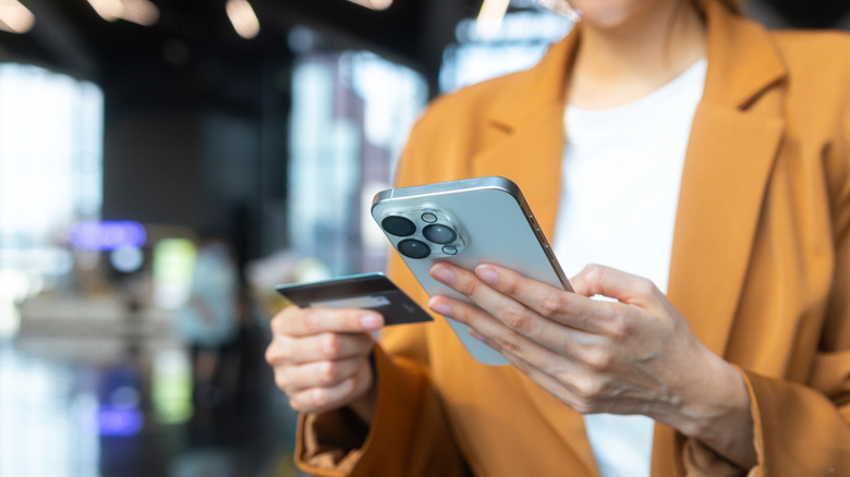 Woman holding a phone and a credit card