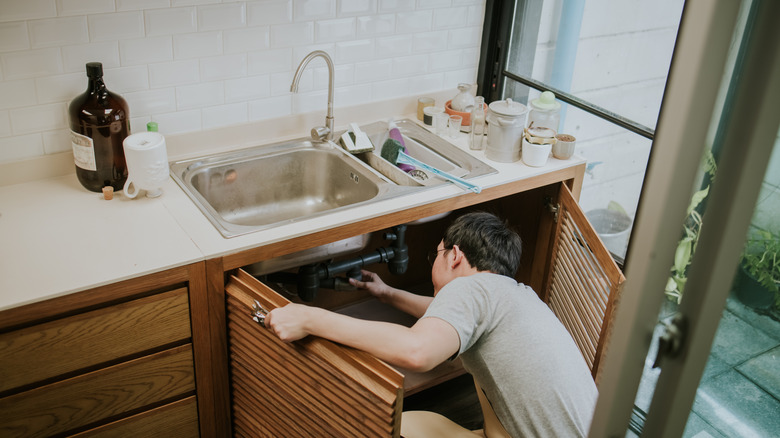 Person fixing a kitchen sink