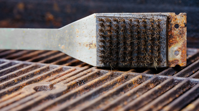 wire grill brush held over a grill