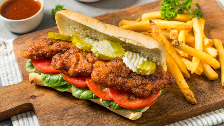 fried fish sandwich with pickles and fresh veggies