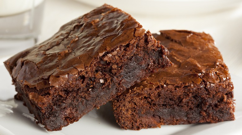 Two homemade brownies on a white plate.