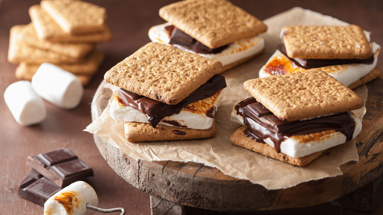Four s'mores on wooden slab