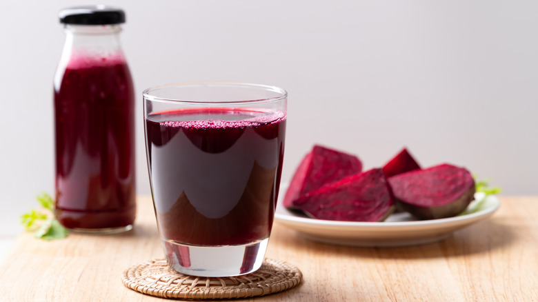 Beet juice in glass next to sliced beets