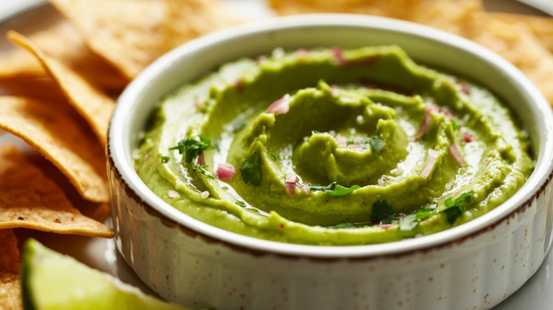 Guacamole in a shallow bowl with tortilla chips.