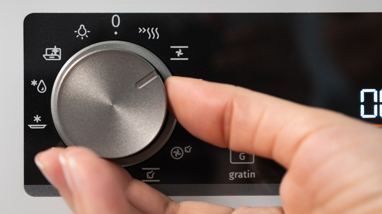 hand adjusting a temperature guage