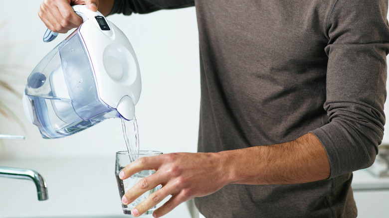 Water filter jug pouring water into a glass