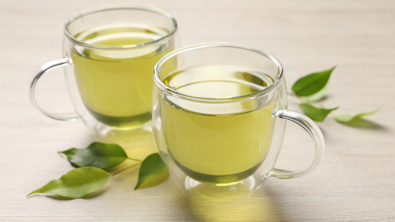 Two glass mugs of green tea