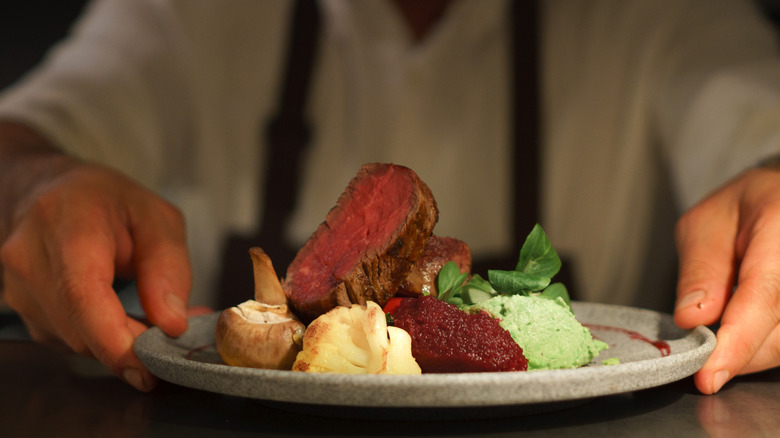 Chef serving plate of food