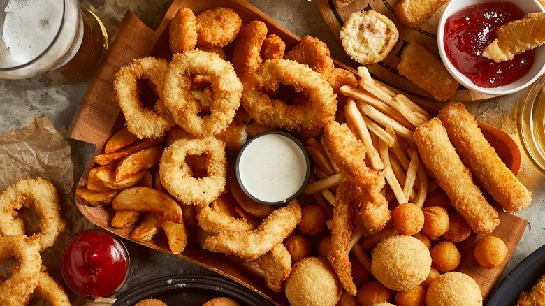 a variety of appetizers, including fries, onion rings, and wedges, on a table