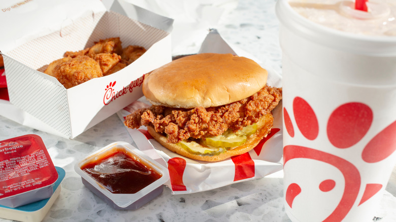 Chick-fil-A chicken sandwich and sauce packs with fries and a drink