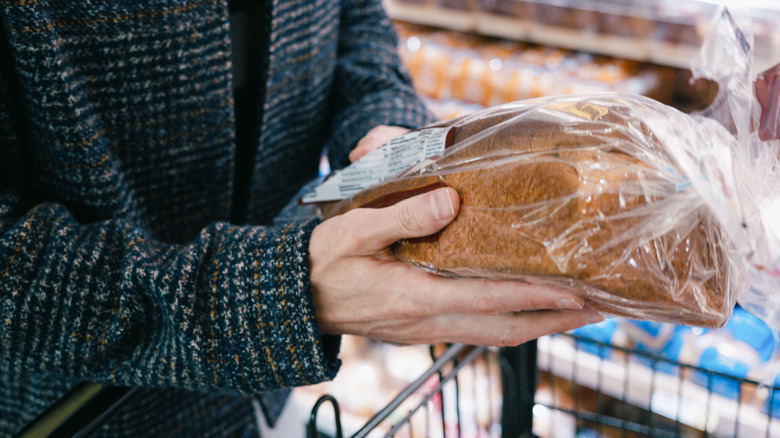 Hands holding a loaf bread in a store