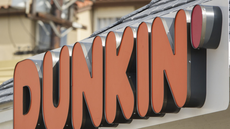 The exterior sign of a Dunkin' coffee shop
