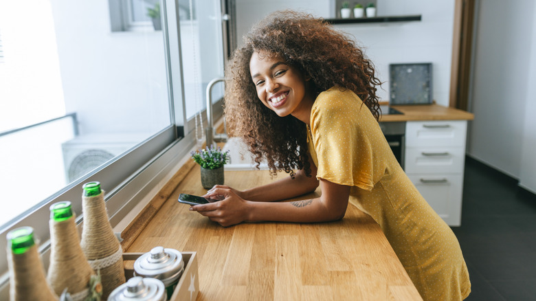 woman leaning on wooden countertops