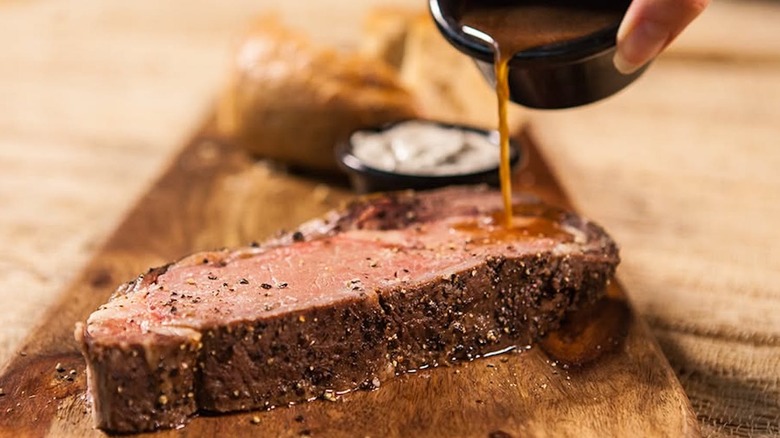 An au jus sauce being drizzled over the now-discontinued Longhorn Steakhouse prime rib.