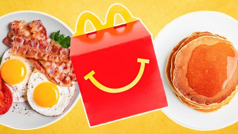McDonald's Happy Meal box next to a plate of eggs and bacon, and a plate of pancakes