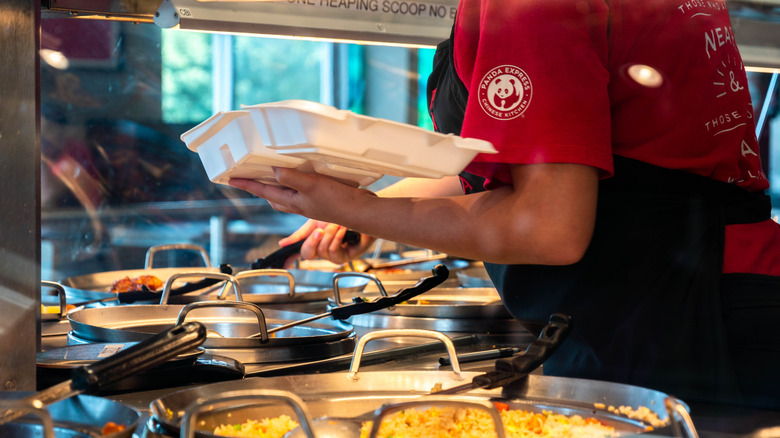 Panda express employee filling a to-go container