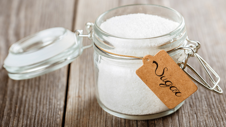 White sugar stored in an open glass jar