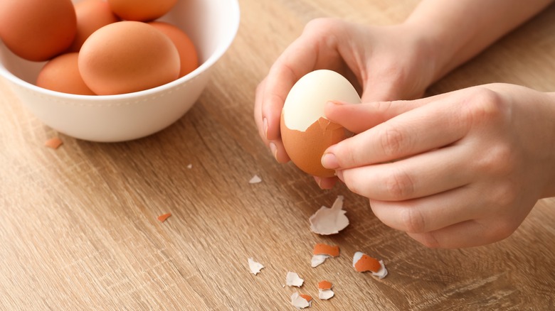 Person peeling a hard boiled egg