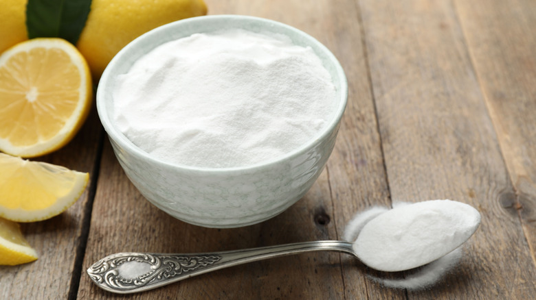 Baking soda and lemons on a wooden table