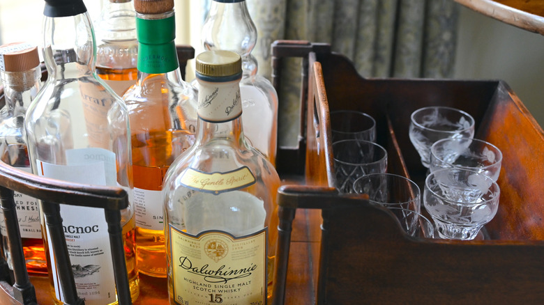 Bottles of whiskey and glasses in a home bar cart