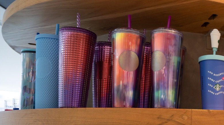 Colorful diamond tumblers and other drink merchandise on a shelf at Starbucks.