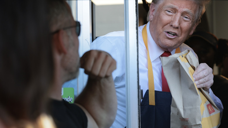 President Donald Trump handing a bag of McDonald's food out of the drive-thru window