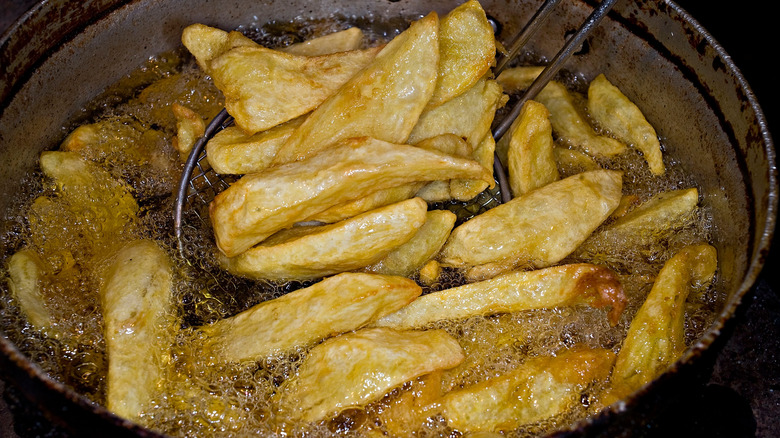 Homemade Greek fries cooking in oil.