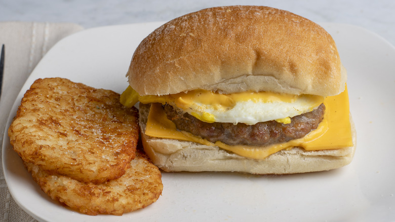 a sausage breakfast sandwich and hash browns