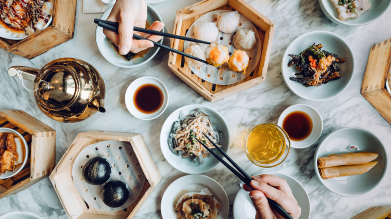 An assortment of Chinese dishes with dipping sauces.